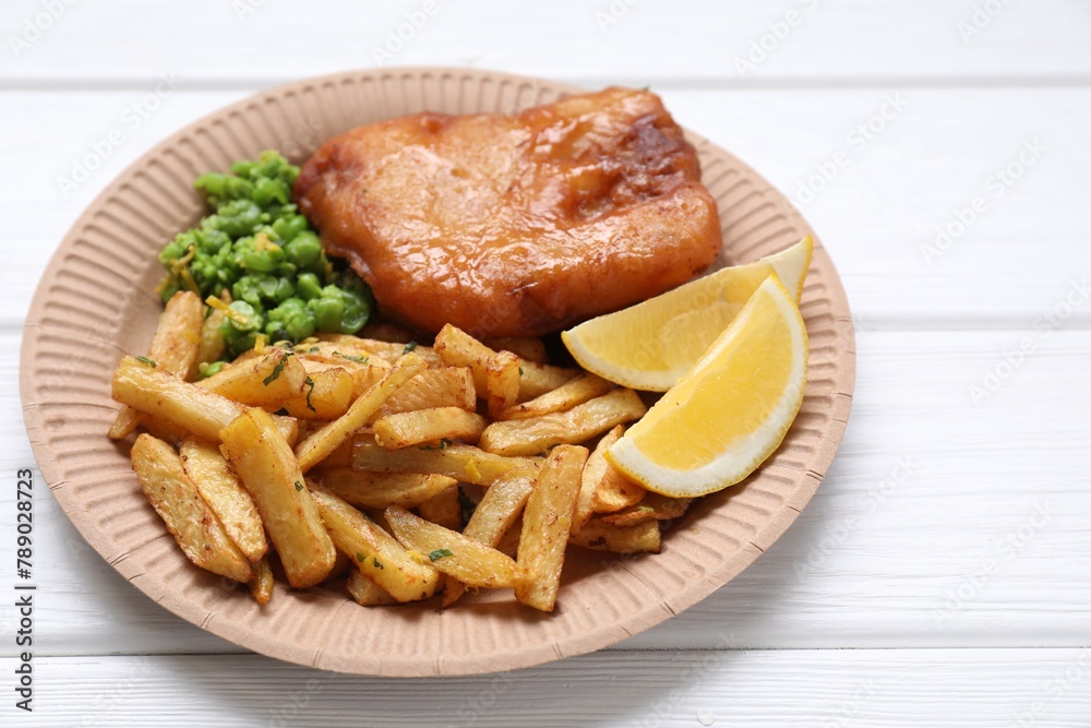 Tasty fish, chips, peas and lemon on white wooden table, closeup Tasty fish, chips, peas and lemon on white wooden table, closeup