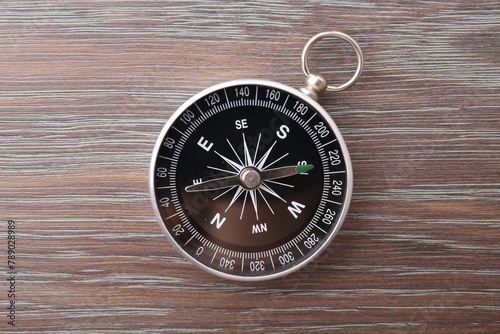 One compass on wooden table, top view. Tourist equipment