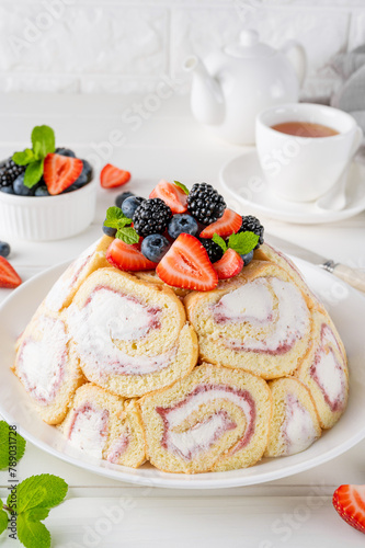 Charlotte Royale Cake with strawberry cream inside and decorated fresh berries. Delicious summer cake.