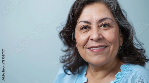 Close up of middle aged latin woman smiling in the light blue blouse looking at the camera : Generative AI