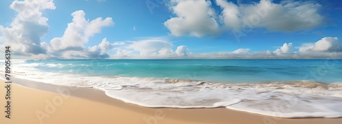 Tranquil sea mirrors the clear blue sky with white clouds above a sandy beach.