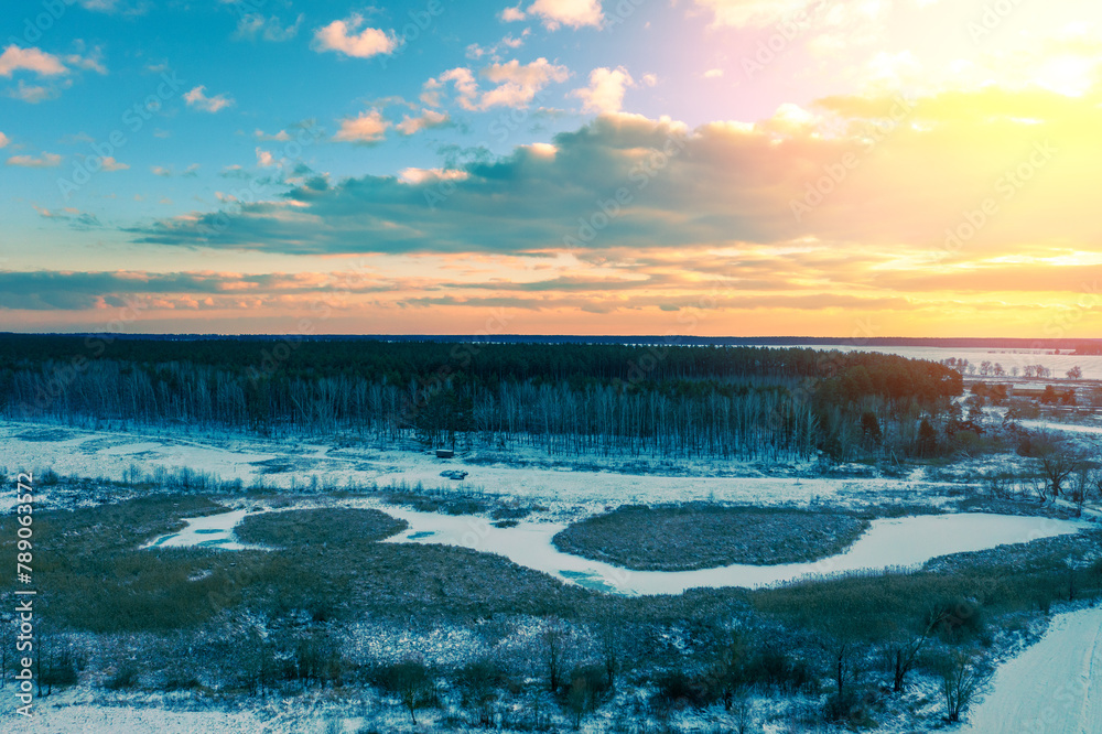 Fototapeta premium Rural landscape in winter. Sunset in the countryside. Drone view