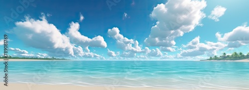 Sandy beach with clear blue sky and clouds reflected in the calm sea.