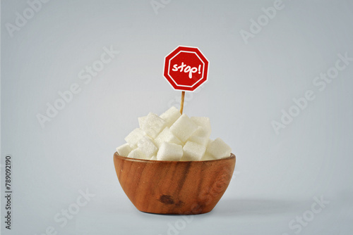 White sugar cubes in wooden bowl with Stop Sign - No sugar diet concept © calypso77