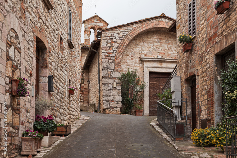 Corciano, Perugia, Umbria, Italy: narrow alley and the ancient Church of San Cristoforo, now home to a museum, in the old town of the picturesque village