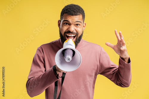 Young African American man announcing the news through loudspeaker while screaming