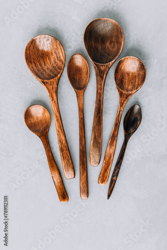 Wooden spoons. Wooden spoons on gray stone background, kitchen concept. © nblxer