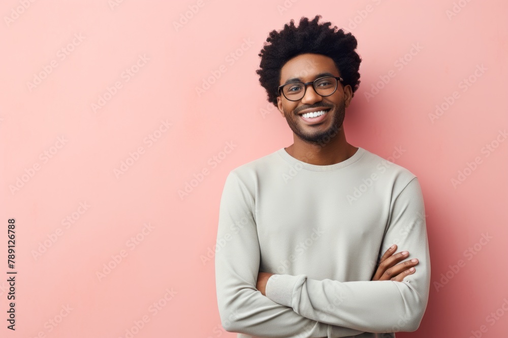 Portrait of a smiling afro-american man in his 30s sporting a long-sleeved thermal undershirt in front of solid pastel color wall Portrait of a smiling afro-american man in his 30s sporting a long-sleeved thermal undershirt in front of solid pastel color wall