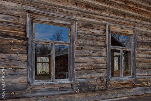 Windows on a weathered old log building.