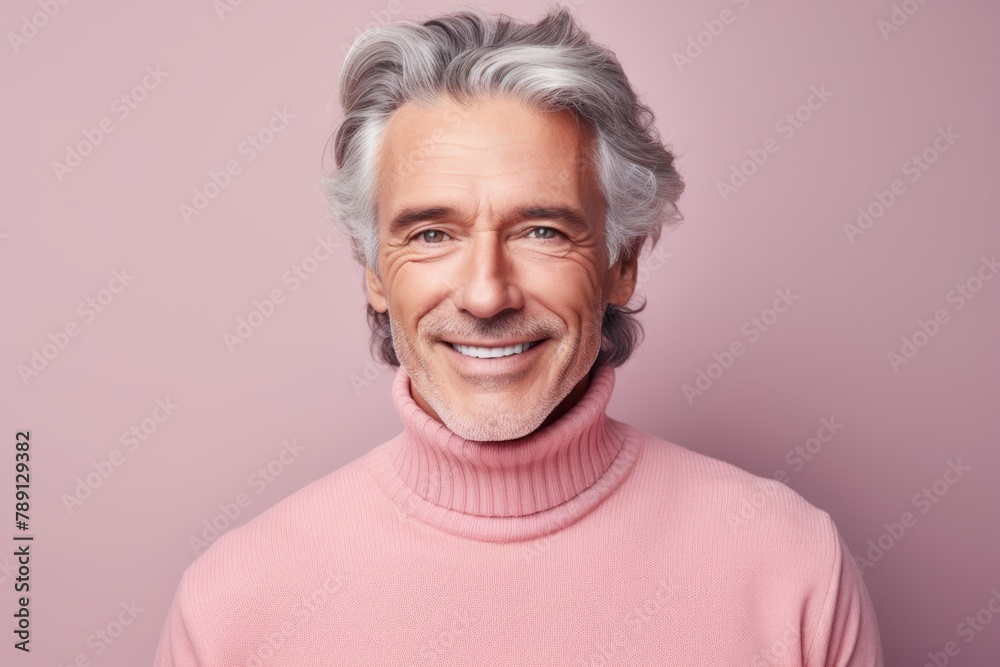 Portrait of a glad man in his 50s showing off a thermal merino wool top in front of solid pastel color wall Portrait of a glad man in his 50s showing off a thermal merino wool top in front of solid pastel color wall
