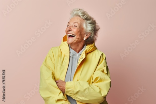 Portrait of a joyful elderly woman in her 90s wearing a functional windbreaker over light wood minimalistic setup