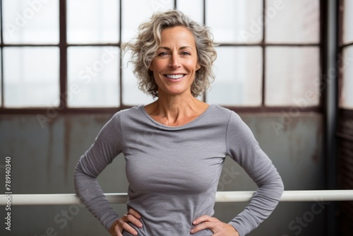 Portrait of a happy woman in her 50s showing off a thermal merino wool top in front of empty modern loft background