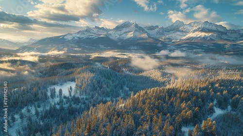 Aerial view of the Rocky Mountains, snow-dusted peaks and forested trails