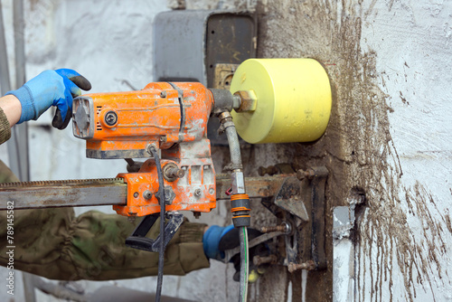 Fotografía Worker using an electric drill to make a hole in a concrete wall, closeup