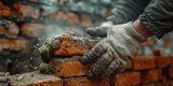 A closeup of the hands and tools used in brickwork, house construction