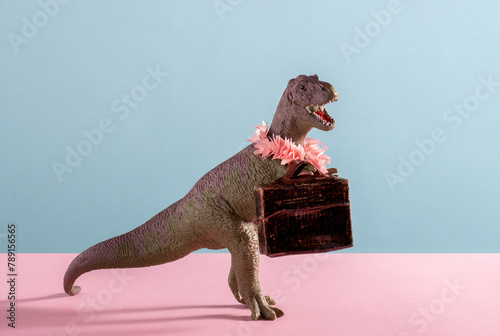 Cute dinosaur with flower necklace and vintage suicase on pink and blue background.