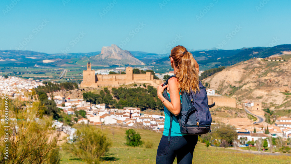Naklejka premium Woman looking at Castle fortress Real Colegiata de Santa Maria La Mayor, Antequera, Spain