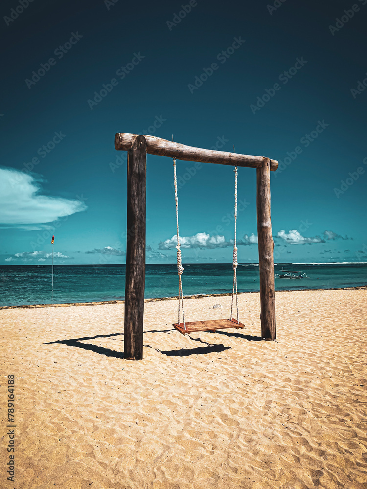 Swing at beach against blue sky
