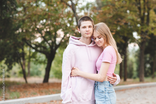 Stylish smiling teenage couple 18-20 year old standing outdoor holding each other close up. Relationship. photo