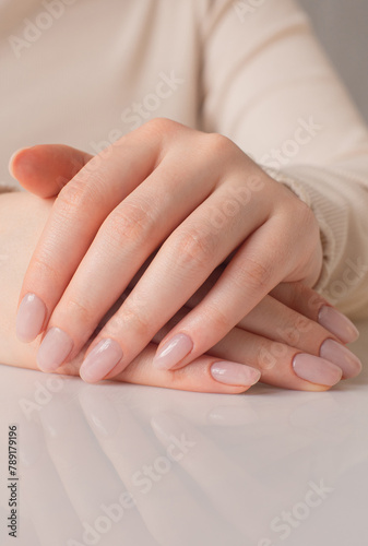 close up of a woman holding her hands on the table, nails and manicure
