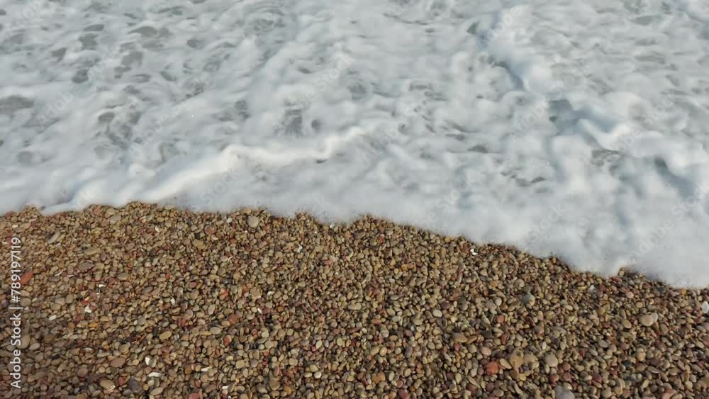 Top-down view of sea waves washing over a beach, alternating between sandy and rocky surfaces, perfect for holiday-themed overlays. Top-down view of sea waves washing over a beach, alternating between sandy and rocky surfaces, perfect for holiday-themed overlays.