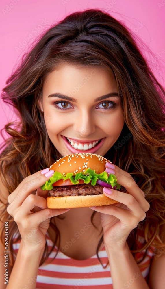 Woman enjoying tasty burger in portrait on soft color background with room for text Woman enjoying tasty burger in portrait on soft color background with room for text