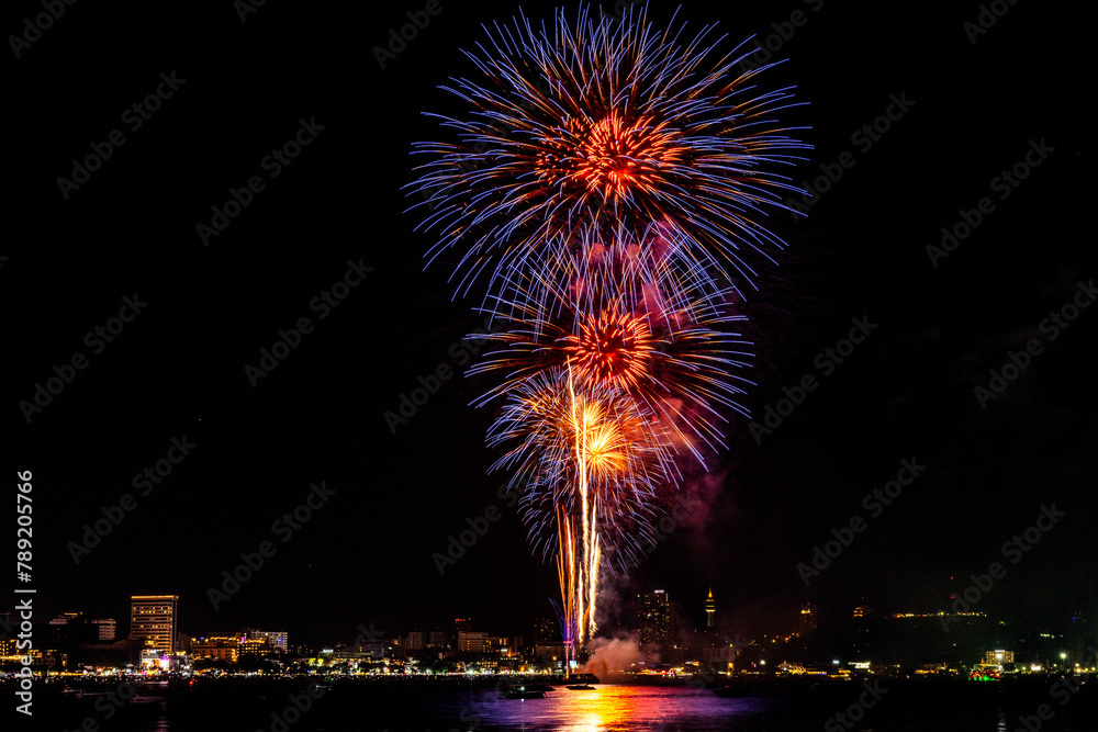 Breathtaking fireworks light up the night sky above a tranquil bay, casting reflections over calm waters. Breathtaking fireworks light up the night sky above a tranquil bay, casting reflections over calm waters.
