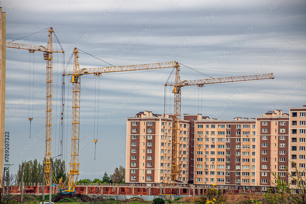 Three construction cranes in the city Three construction cranes in the city