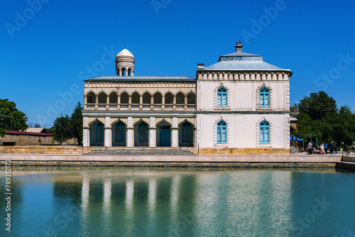 Emir's Summer Palace in Bukhara reflected in pond, clear sky, exemplifying Uzbek architecture. Bukhara, Uzbekistan