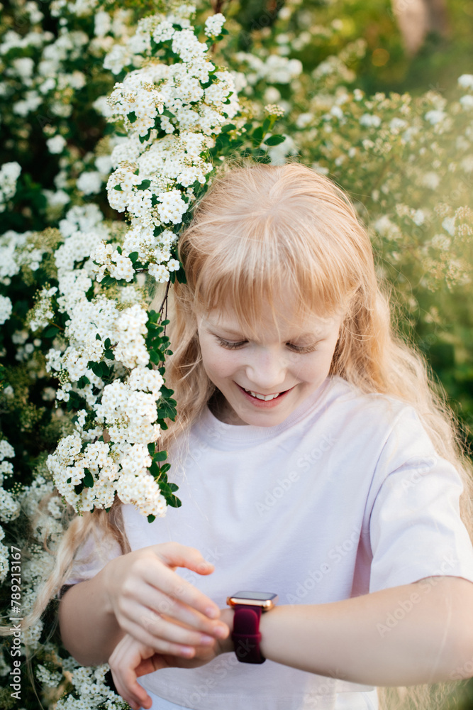 girl child on a sunny spring day laughs and looks at the time girl child on a sunny spring day laughs and looks at the time