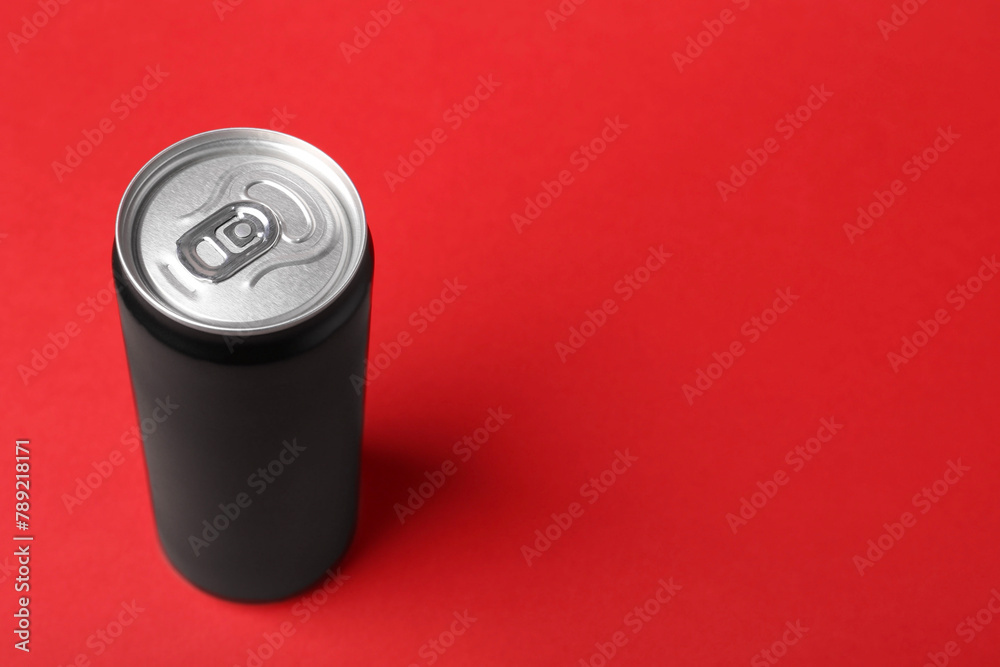 Energy drink in can on red background, space for text Energy drink in can on red background, space for text