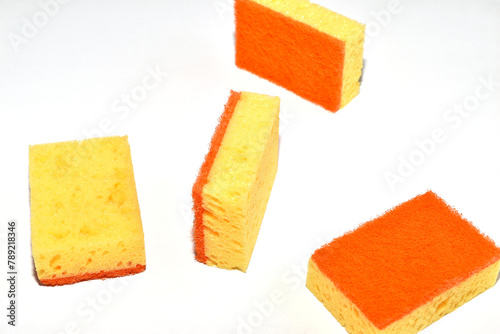 Dishwashing sponges are scattered on a white background.