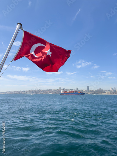 Turkish flag on the sky over bosporus sea and city view in Istanbul, Turkey