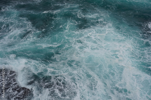 The white crashing waves and the emerald sea