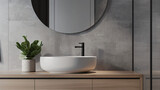 Close up of basin with oval mirror standing in on grey
