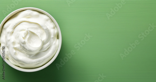 Top view of bowl with white quark or cream on side of green background with copy space сreated with Generative Ai