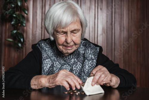 Portrait of an old woman counting money. The concept of old age, poverty, austerity