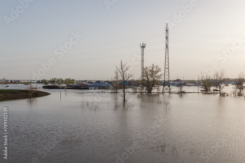 Flood in Kazakhstan. A village flooded with water. The river overflowed its banks. Melt water in the field. Power line support in flood water.