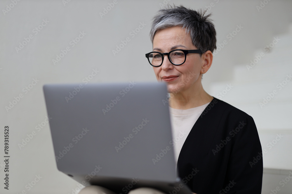 A professional businesswoman works from her home office, utilizing technology and internet for success. A professional businesswoman works from her home office, utilizing technology and internet for success.