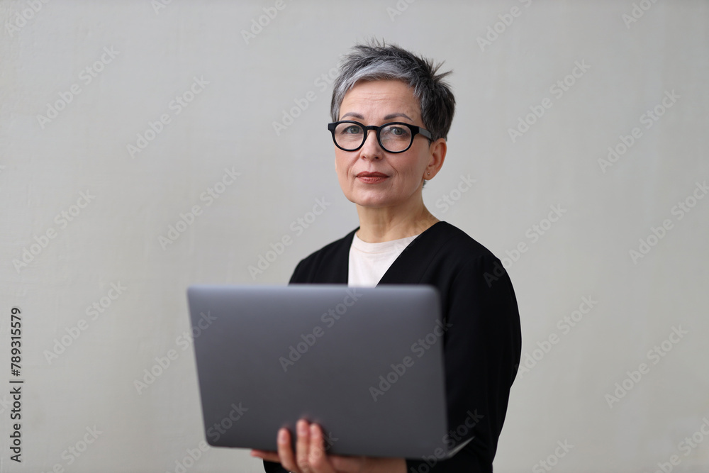 A mature entrepreneur, working on her laptop in a modern office, embodies professionalism and success. A mature entrepreneur, working on her laptop in a modern office, embodies professionalism and success.