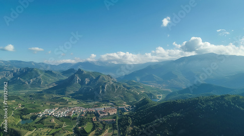 A bird s-eye view of Berga  located in Catalonia  Spain  nestled within a valley  with the mountains of Serra de Campons and Serra de Picancel in the distant background.