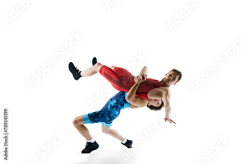 Young boys, athletes wrestling, training, displaying skill and strategy for victory, isolated on white background. Concept of combat sport, martial arts, competition, tournament, athleticism