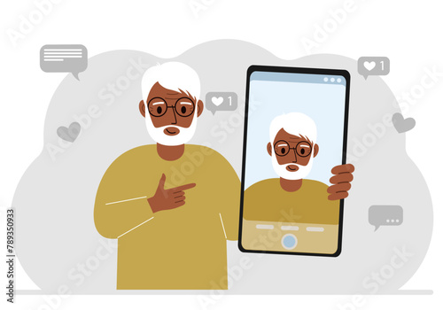 A male video blogger records or watches a video or photo on a smartphone. Various social media icons.