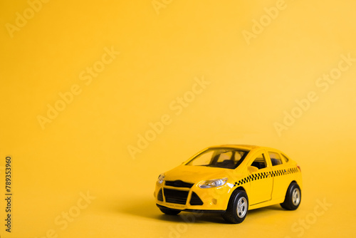 Urban taxi and delivery service concept. Toy yellow taxi car model. Copy space for text  banner. Online mobile application order taxi service.