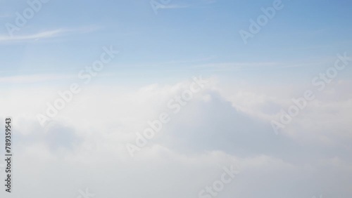 blue sky with white fluffy clouds fromm airplane flight fly over the clouds in a sunny day with cloud moving in summer photo