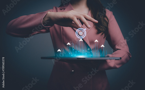 Business goal and target success concept. Businesswoman touching a virtual screen with a target icon and arrows pointing up. Global economic trend analysis, Financial graph analysis.