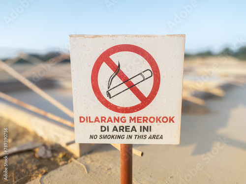 warning board with the words dilarang merokok di area ini in English no smoking in this area photo