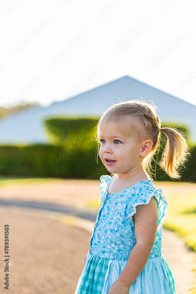 Little girl watching cars go past on road Little girl watching cars go past on road