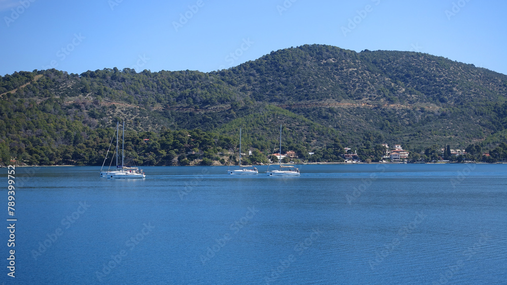 Sail boats near picturesque village of Poros island, Saronic Gulf, Greece Sail boats near picturesque village of Poros island, Saronic Gulf, Greece