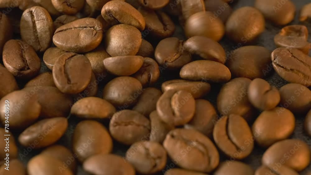 Roasted coffee beans poured on dark textured table, macro close up background, copy space. Roasted coffee beans poured on dark textured table, macro close up background, copy space.